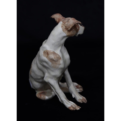 38 - A Studio glazed earthenware figure of a seated dog on white and brown ground, indistinctly stamped w... 