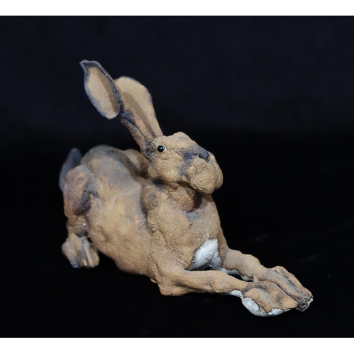 39 - A Studio earthenware figure of a hare with glass eyes (tail restored)