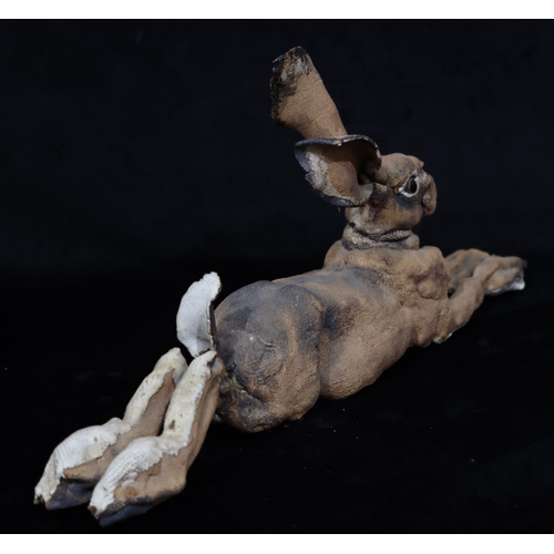 44 - A large Studio glazed earthenware figure of a resting Hare (Both back legs restored), 59.5cm long, 2... 
