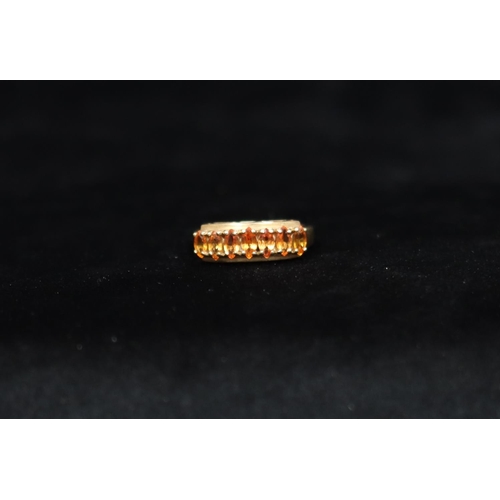 459 - A 9ct gold ladies' ring set with various orange stones, Size O/P, 3.6 grams gross