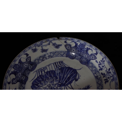52 - A Chinese blue and white charger with bamboo, floral, tree and scroll decoration (chip and rivetted ... 