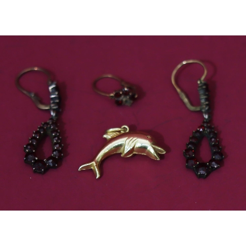 566 - A 14ct gold charm in the form of a dolphin, 1 gram, a pair of garnet drop earrings and a single garn... 