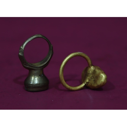 590 - An ancient style gilt metal ring set with striped stone, Size S/T, a similar ancient style ring set ... 