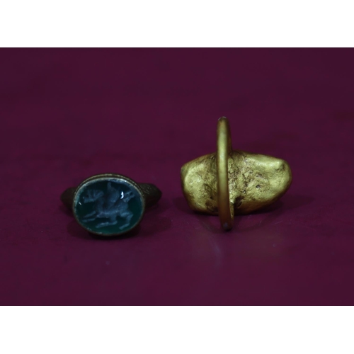 590 - An ancient style gilt metal ring set with striped stone, Size S/T, a similar ancient style ring set ... 