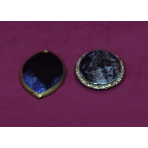 598 - An oval gilt agate style brooch with raised floral and scroll rim (cracked), a similar brooch (2)