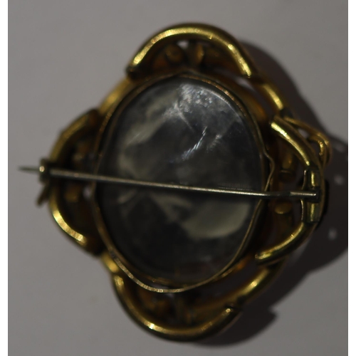 602 - A 19th Century oval mourning brooch with twist centre, depicting cameo figurehead of a lady with gla... 