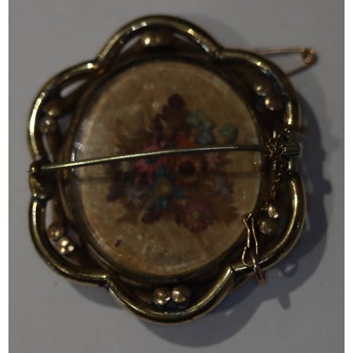 606 - An oval brooch with floral swivel centre, 5.3cm wide