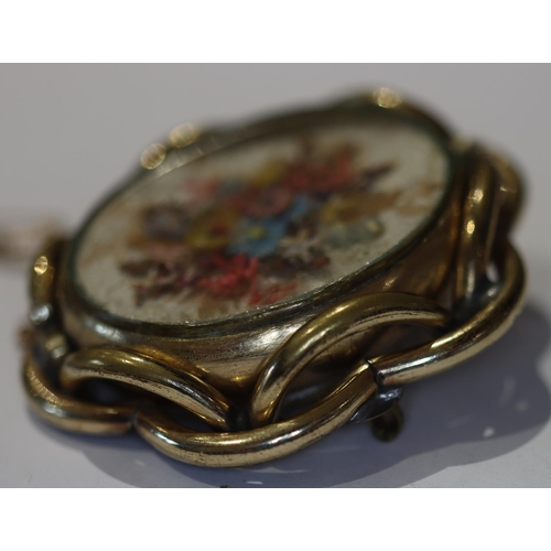 606 - An oval brooch with floral swivel centre, 5.3cm wide