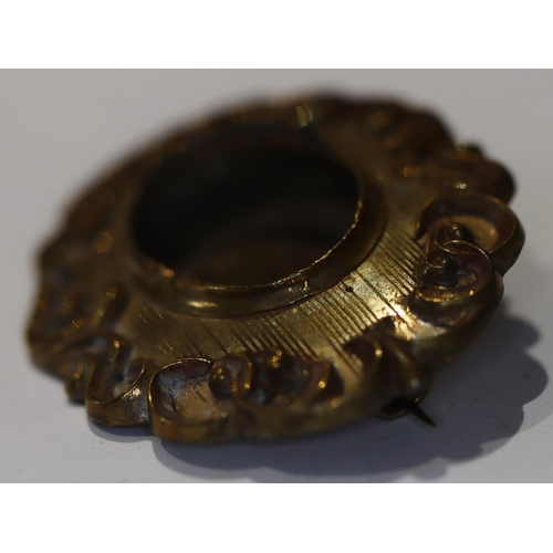 610 - A 19th/20th Century oval mourning brooch (centre matted hair missing) with raised scroll rim, 4.8cm ... 