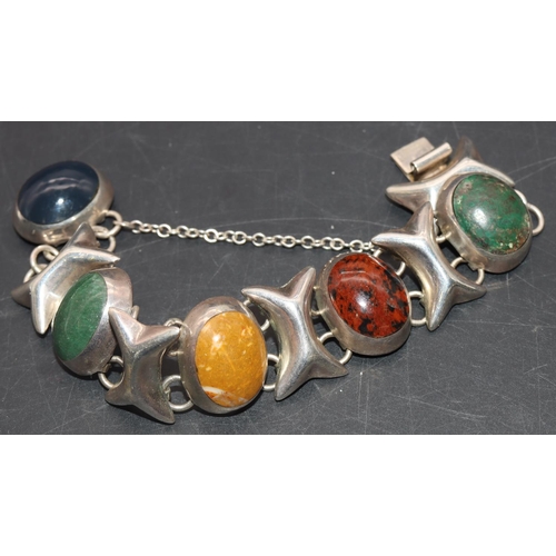 652 - A silver heavy bracelet mounted with various coloured oval stones, 74.5 grams gross