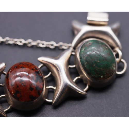 652 - A silver heavy bracelet mounted with various coloured oval stones, 74.5 grams gross