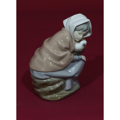69 - A Nao figure of a young sleeping seated girl holding a basket with bird, 17cm high