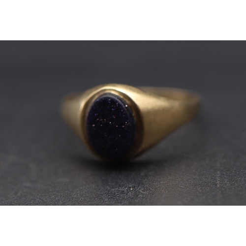 699 - A small gold signet ring set with oval glittering blue stone, Size L, 1.2 grams