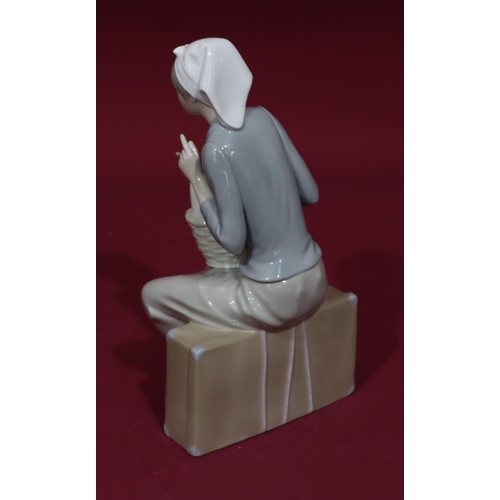 70 - A Nao figure of a seated young lady with a goose in a basket on her lap, 27cm high