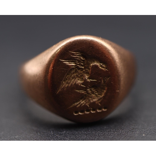 702 - A gentlemen's gold small signet ring set with etching of 2 fighting birds, Size L/M, 5.4 grams