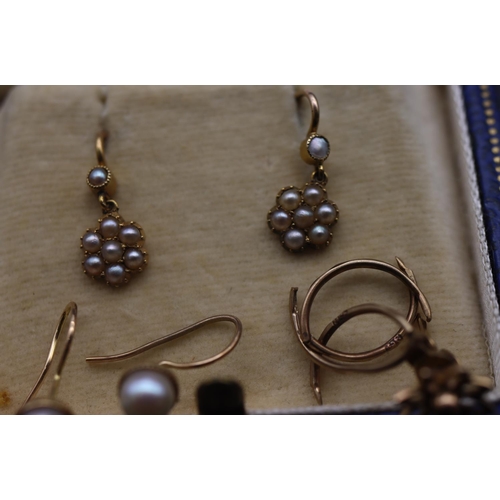 707 - A pair of gold drop earrings set with half pearls, a pair of small gold earrings set with pearls and... 