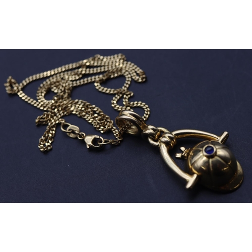 713 - An 18ct gold Piaget novelty equestrian pendant in the form of a jockey's cap, inset with cabochon sa... 