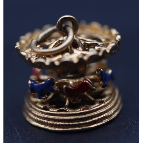 718 - A small charm in the form of a carousel with enamel decoration, 2.7 grams gross