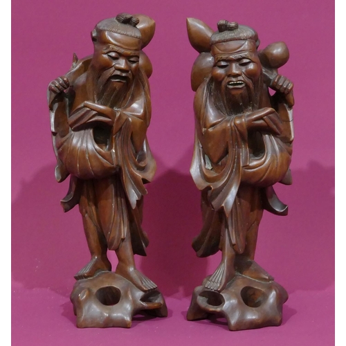 730 - A pair of Oriental hardwood figures of standing gentlemen, 31cm high