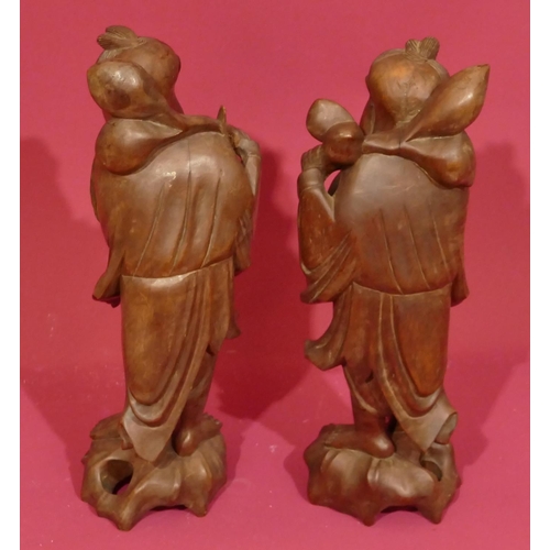 730 - A pair of Oriental hardwood figures of standing gentlemen, 31cm high