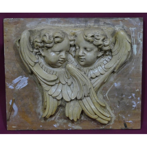 745 - A plaster plaque depicting 2 figureheads of cupids mounted on board, later painted, board 61cm x 74c... 