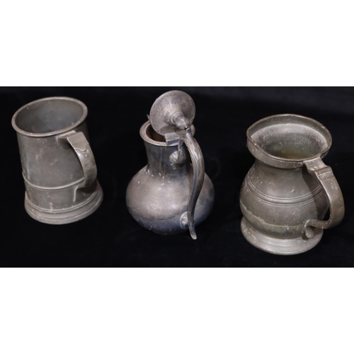 749 - An antique pewter pot-bellied tankard, a similar pewter tankard and a Britannia metal hot water jug ... 