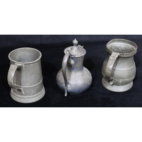 749 - An antique pewter pot-bellied tankard, a similar pewter tankard and a Britannia metal hot water jug ... 