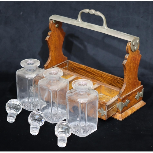 752 - A Victorian oak 3 bottled Tantalus with centre carrying handle, slide out tray containing 3 square d... 