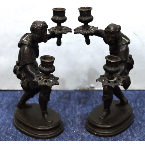 760 - A pair of bronze candlesticks in the form of a standing gentleman on oblong bases, 25cm high