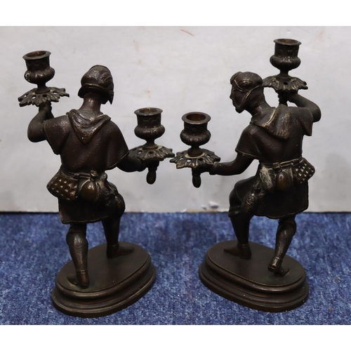 760 - A pair of bronze candlesticks in the form of a standing gentleman on oblong bases, 25cm high