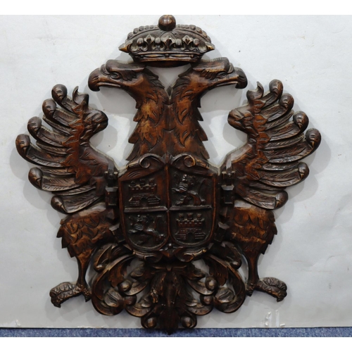 761 - A carved wooden hanging crest with eagle motifs, 84.5cm high, 58cm wide