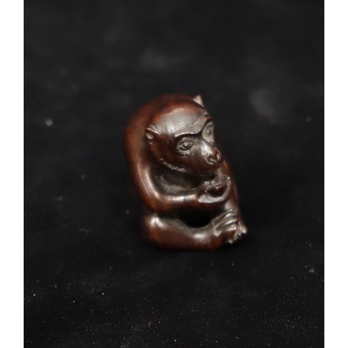 806 - A carved wooden netsuke of a monkey