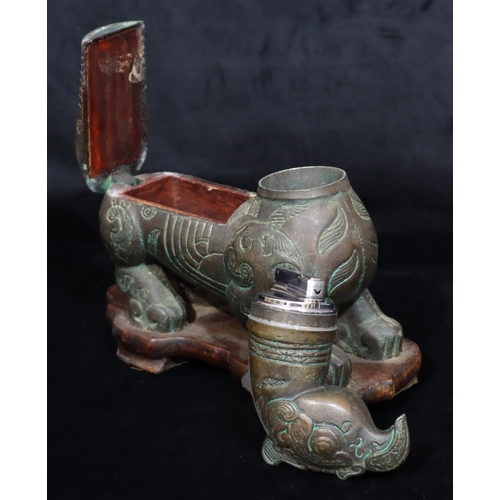 808 - A bronzed table light/cigarette box in the form of a mythological animal, allover leaf and scroll de... 