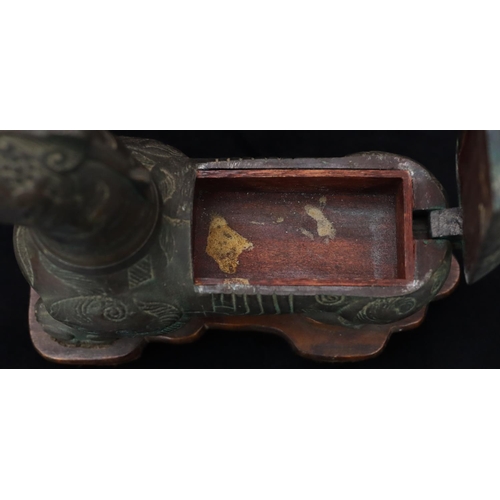 808 - A bronzed table light/cigarette box in the form of a mythological animal, allover leaf and scroll de... 