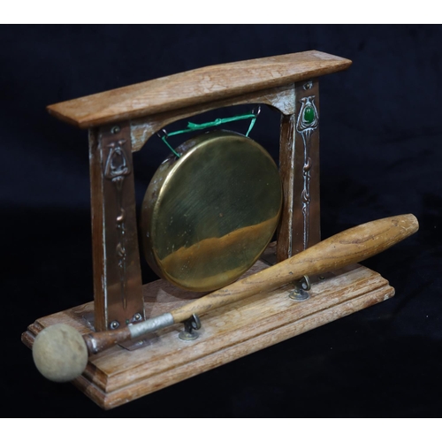 813 - An Arts and Crafts oak table gong with copper embossed mounts with green carbuncles (1 missing), bra... 