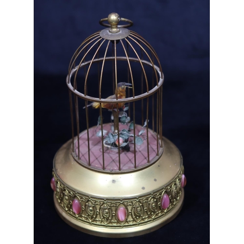 817 - A gilt metal and feathered singing bird in a cage with raised pink carbuncles (1 foot missing and ov... 