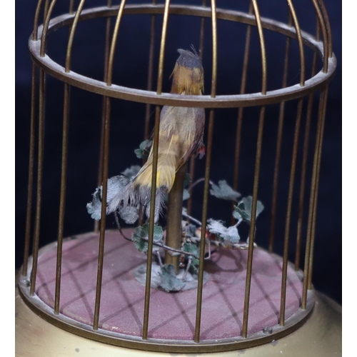 817 - A gilt metal and feathered singing bird in a cage with raised pink carbuncles (1 foot missing and ov... 