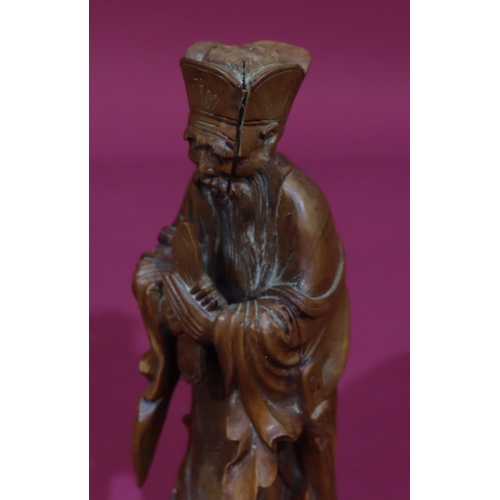 831 - A carved Oriental wooden figure of a standing gentleman, 26cm high