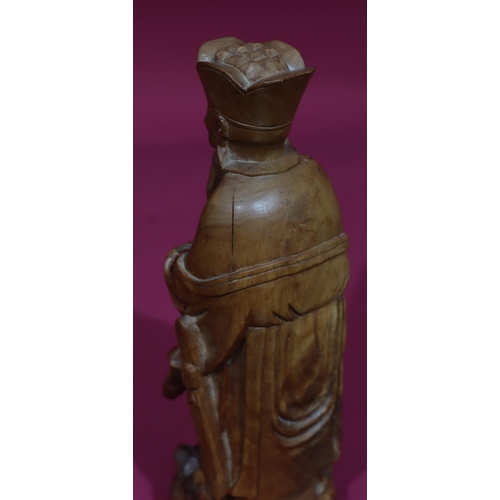 831 - A carved Oriental wooden figure of a standing gentleman, 26cm high