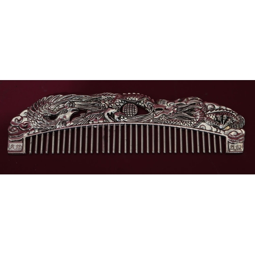 834 - A metal comb with Oriental raised dragon decoration, 16cm long