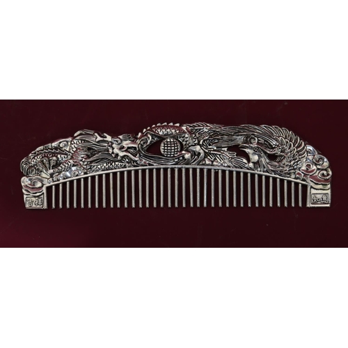 834 - A metal comb with Oriental raised dragon decoration, 16cm long