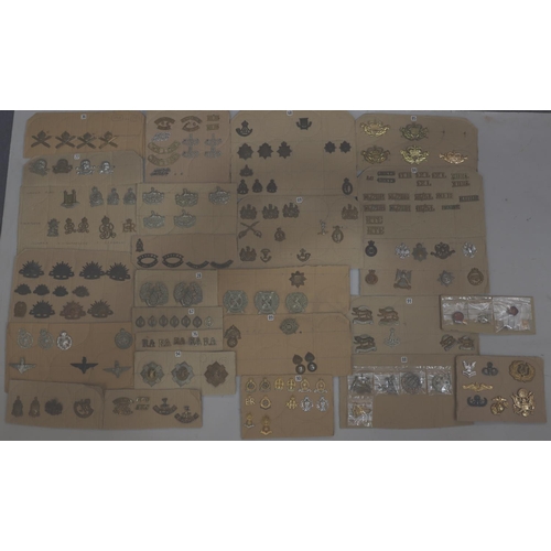 846 - A quantity of various military and other cap badges etc mounted on 26 cut down boards