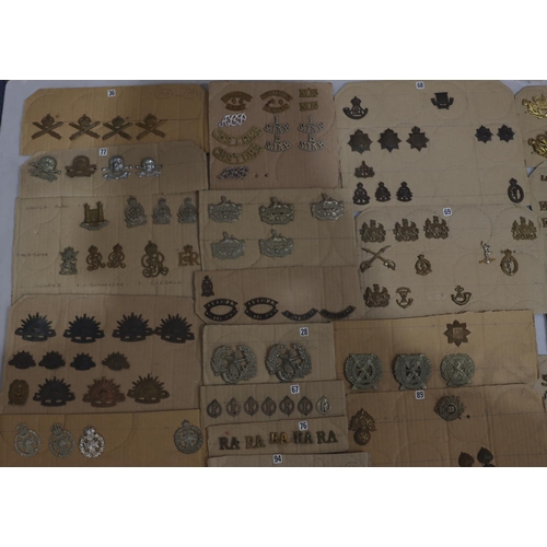 846 - A quantity of various military and other cap badges etc mounted on 26 cut down boards