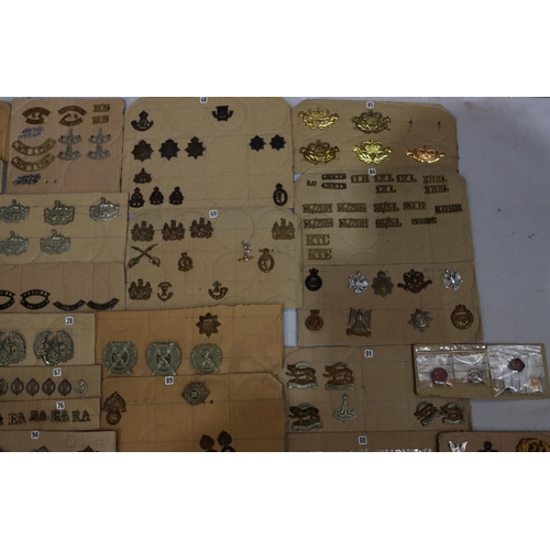 846 - A quantity of various military and other cap badges etc mounted on 26 cut down boards