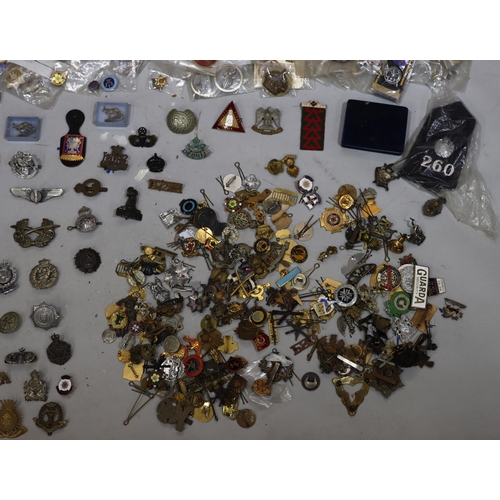 852 - A large quantity of various military and other badges including belts etc.