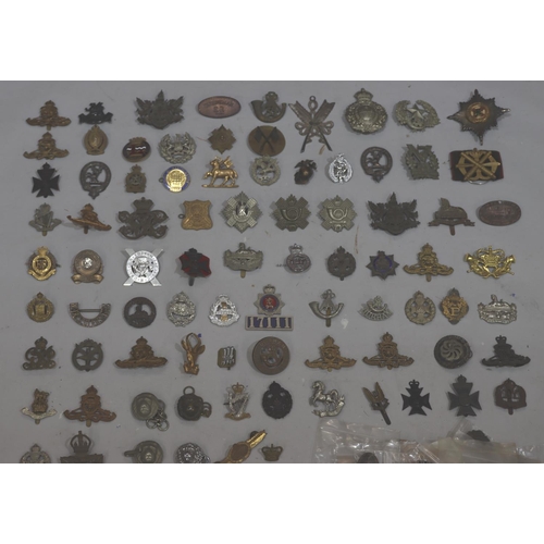 853 - A large quantity of various military and other badges including belts etc.