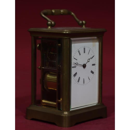 919 - A brass half-striking carriage clock with white enamel dial and Roman numerals, swing overhead handl... 