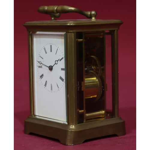 919 - A brass half-striking carriage clock with white enamel dial and Roman numerals, swing overhead handl... 