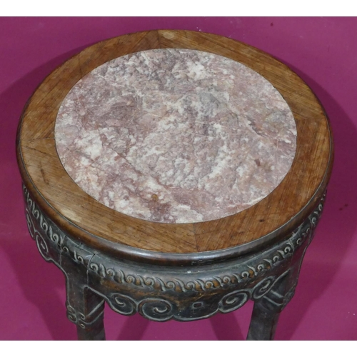 930 - A Chinese round hardwood stand with marble inset top and raised carved scroll decoration on 4 legs w... 