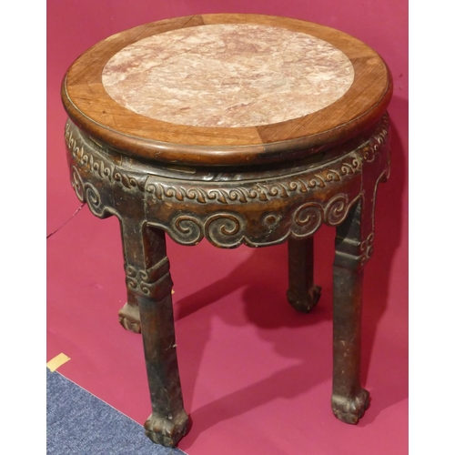 930 - A Chinese round hardwood stand with marble inset top and raised carved scroll decoration on 4 legs w... 